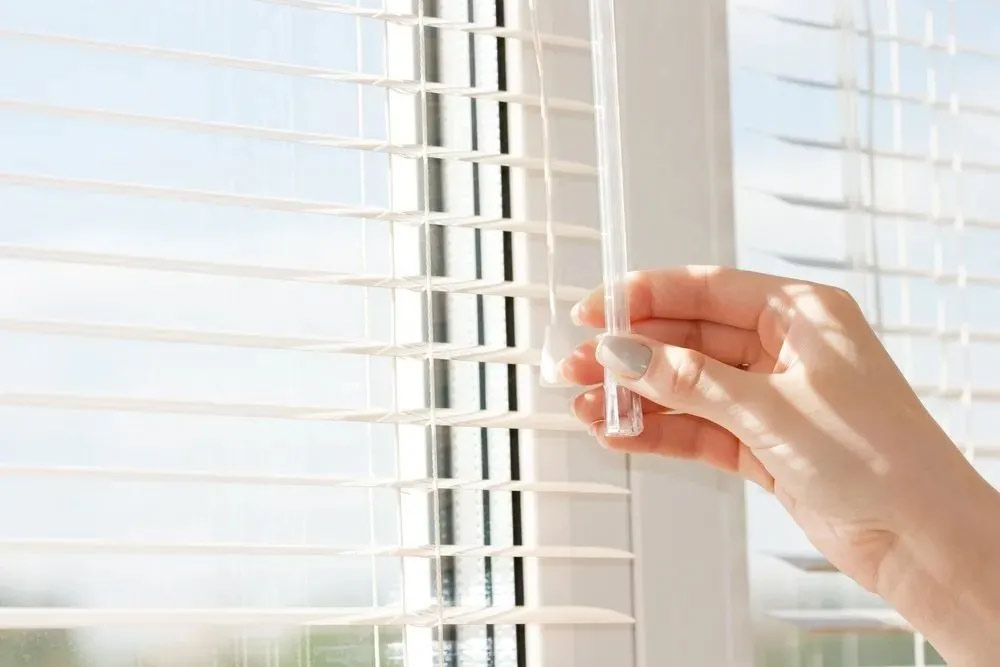 a person holding a tube with a tube in front of a window